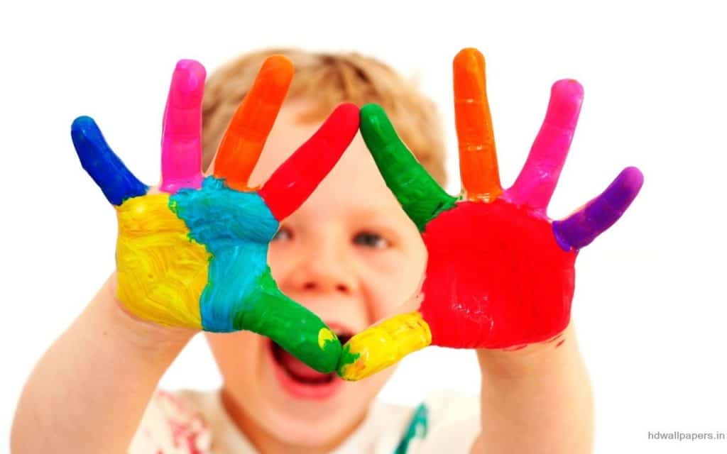 kid with rainbow hands paint